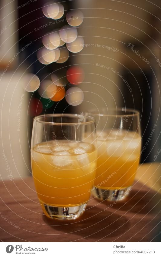 Drinks mit Eis und Lichter Bokeh eiswürfel getränk getränke alkohol gläser anstoßen orange bitter kräuter weihnachten festlich glamour bokeh glitzer
