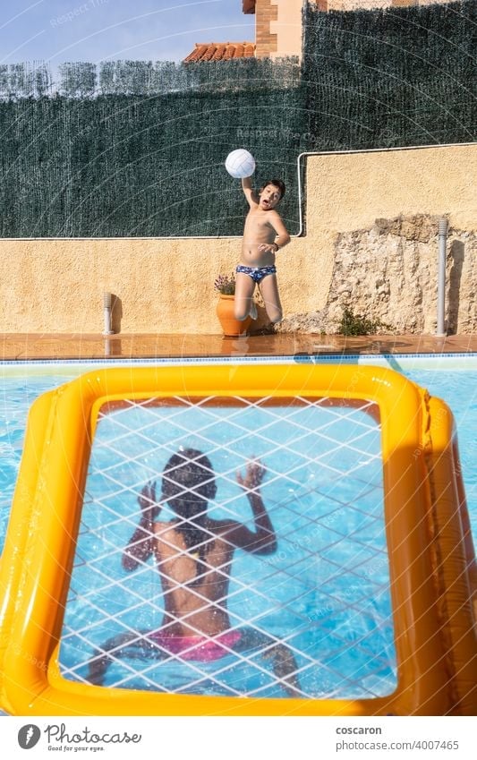 Zwei Kinder spielen mit einem Ball auf einem Pool aktiv Aktivität aquatisch Strand blau Junge Kaukasier Kindheit Energie Familie Spaß Spiel Mädchen Tor Typ
