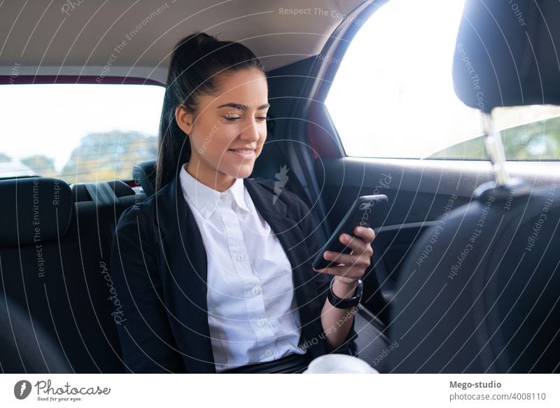 Geschäftsfrau benutzt Mobiltelefon im Auto. Frau PKW Mobile Telefon Taxi Transport Kabine männlich eine Porträt Erwachsener professionell zur Arbeit gehen