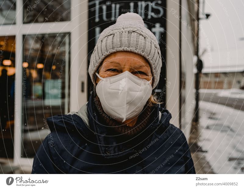 Frau mit Maske vor Geschäft corona pandemie maske COVID Infektionsgefahr Coronavirus covid-19 Schutz Mundschutz Prävention einzelhandel geschäft zusammenhalt