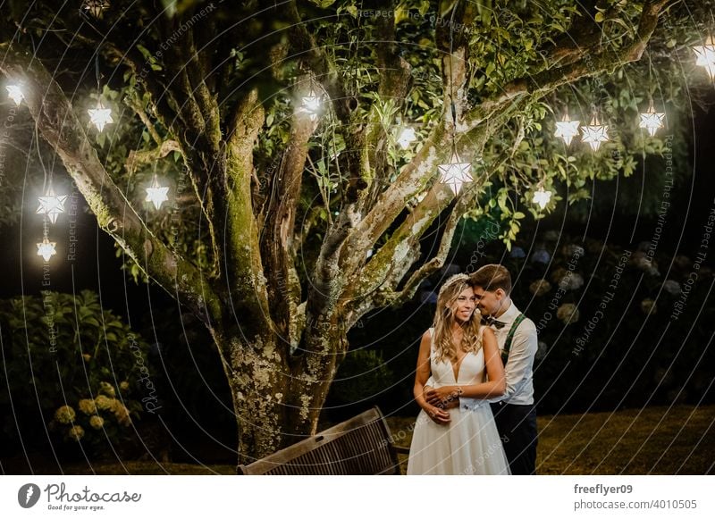 Ehepaar unter einem Baum an ihrem Hochzeitstag Heirat Engagement Braut Menschen jung attraktiv Textfreiraum Nacht Lichter Schmuckanhänger Natur außerhalb Liebe