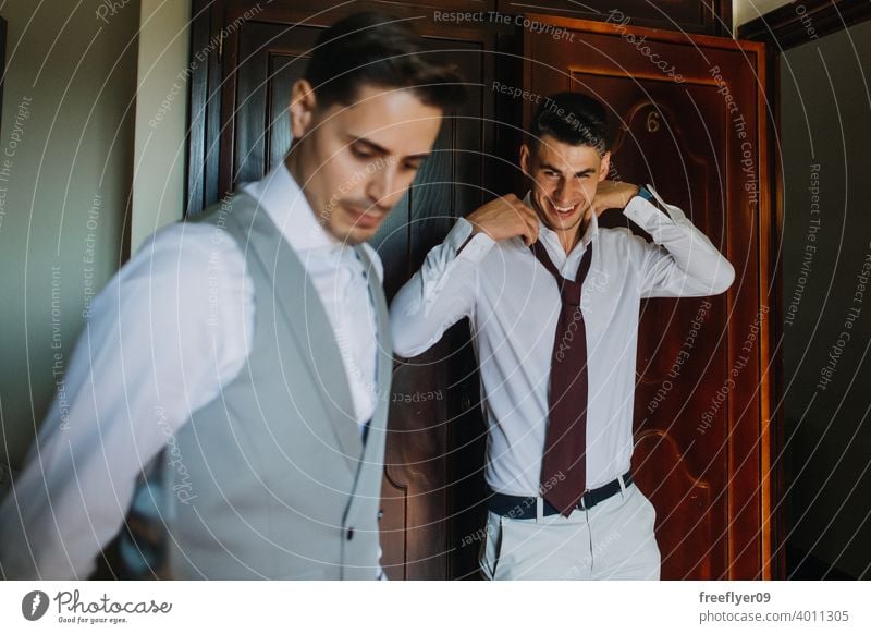 Bräutigam und Trauzeuge beim Anziehen des Anzugs Porträt striegeln Hochzeit Heirat Engagement Menschen jung attraktiv Textfreiraum Mann männlich 20s Raum