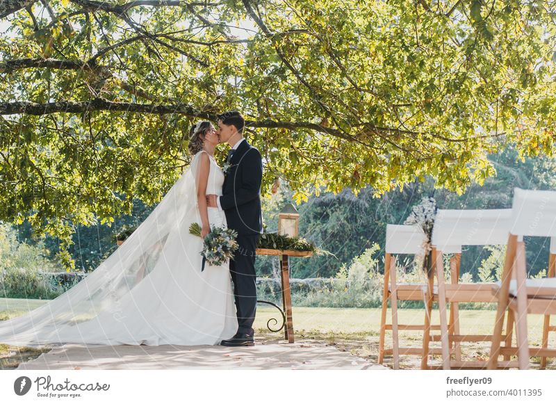 Junges Paar schaut sich an ihrem Hochzeitstag an Heirat Engagement Braut Menschen jung attraktiv Textfreiraum striegeln Baum Natur Außenseite Sonnenlicht Sommer