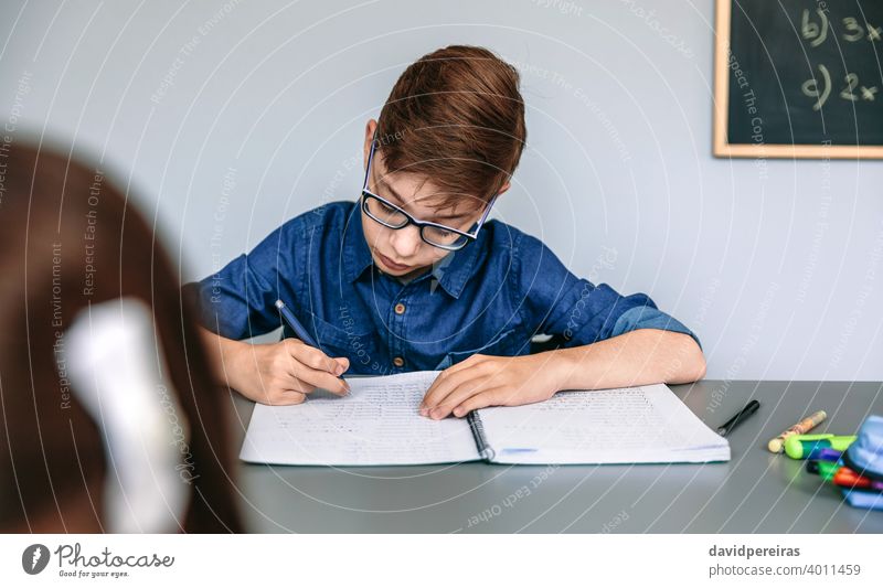 Teenager schreibt in Notebook in der Schule Schüler Klassenraum schreibend konzentriert Bildung fleißig Menschen jung Mädchen Frau zwei Junge Person Kind Kinder