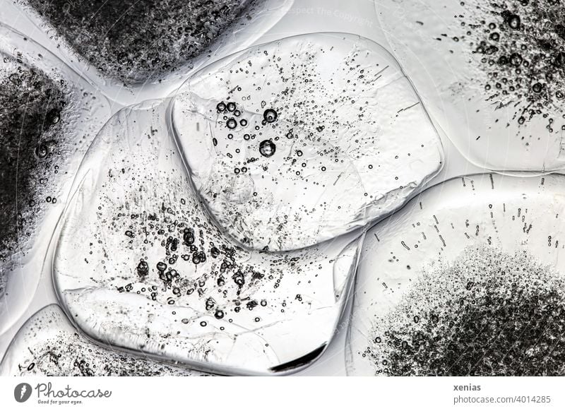 schmelzende durchsichtige Eiswürfel mit Luftblasen und runden Ecken kalt gefroren Wasser rechteckig Eisstruktur Struktur frieren Hintergrundbild Winter