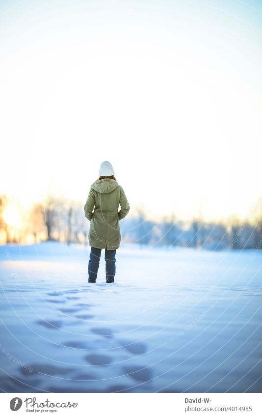 Frau macht einen Winterspaziergang durch den Schnee und genießt die Ruhe Natur winterlich Wintertag Wintereinbruch Kälte frieren ruhe genießen Winterlicht
