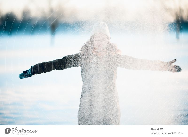 junge Frau wirft Schnee in die Luft Winter Freude Spaß Wetter Jahreszeiten weiß Mädchen Schneefall kalt Natur