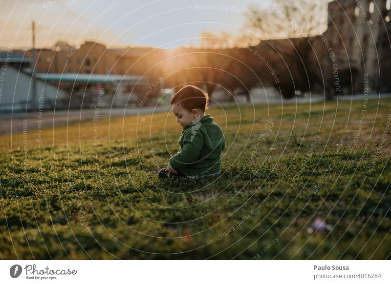 Kleinkind spielt im Park Sonnenuntergang grün Gras authentisch Genuss Spielen Freude Außenaufnahme Natur Mensch Lifestyle Kind Sommer Glück Kindheit niedlich