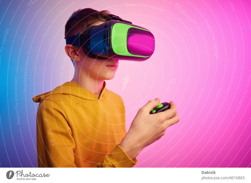 Junge mit Virtual-Reality-Brille auf buntem Hintergrund. Zukunftstechnologie, VR-Konzept Headset virtuell Realität Schutzhelm Technik & Technologie Gerät Spiel