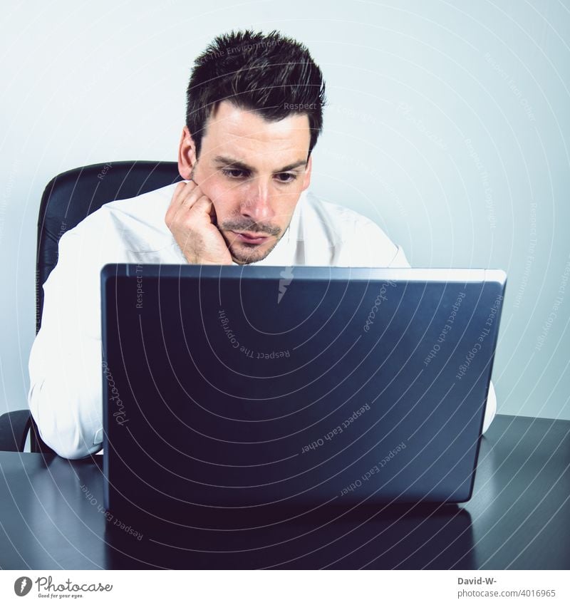Mann am Laptop Homeoffice ernst konzentriert Computer arbeit online Arbeit arbeiten Arbeitsplatz