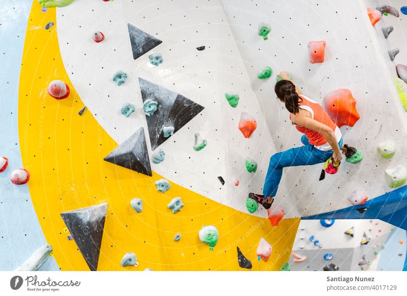Felskletterer Frau schaut auf Smartphone. Aufsteiger Klettern Felsen im Innenbereich Wand Fitnessstudio jung Training Sport Freizeit aktiv Sicherheit extrem