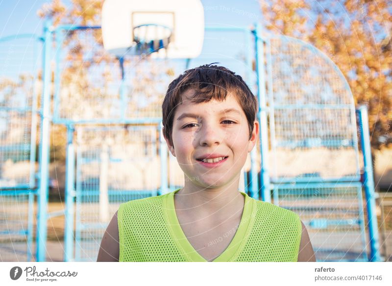 Porträt eines jungen männlichen Teenagers mit ärmellosen stehend auf einer Straße Korbplatz beim Lächeln in die Kamera Basketball Gericht Spieler wirklich