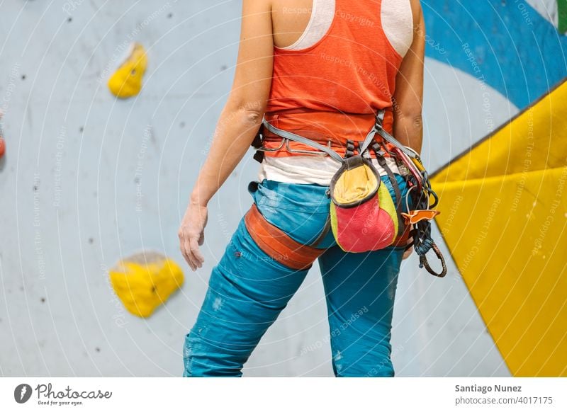 Frau macht sich bereit für das Klettern in der Halle. Aufsteiger Hände abschließen unkenntlich Rückansicht Magnesium Tasche Felsen weiß im Innenbereich Wand
