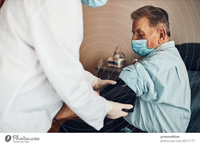 Der Arzt prüft den Blutdruck und die Herzfrequenz eines älteren Mannes. Überprüfung des Gesundheitszustands älterer Patienten, die an arterieller Hypertonie leiden