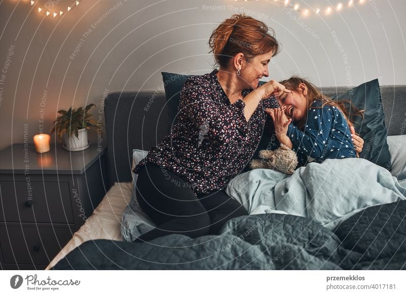 Mutter spielt mit ihrer kleinen Tochter im Bett, Spaß haben, bevor Sie schlafen gehen Kind Familie Frau Kaukasier heimwärts Mädchen wenig Eltern Zusammensein