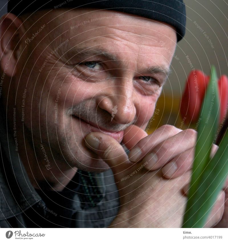 Die Heiterkeit mann mütze blick lächeln tulpe blume gesicht portrait neugierig zufrieden schmunzeln vergnügt vergnüglich heiter heiterkeit