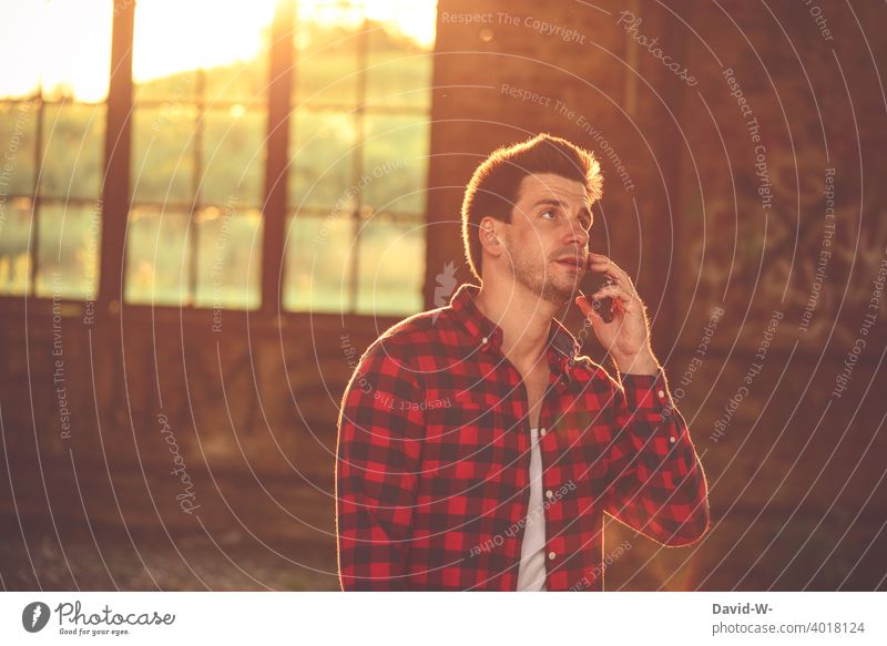Mann telefoniert mit dem Handy telefonieren Sonnenlicht Sonnenschein Gespräch mobil besprechen Smartphone Lifestyle erreichbar