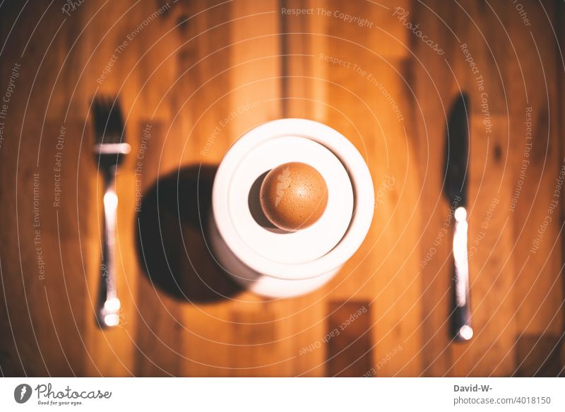 Ei auf einem Teller mit Besteck auf einem Tisch Ostern Messer Gabel Diät Essen Ernährung Minimalismus Mahlzeit gedeckt minimalistisch