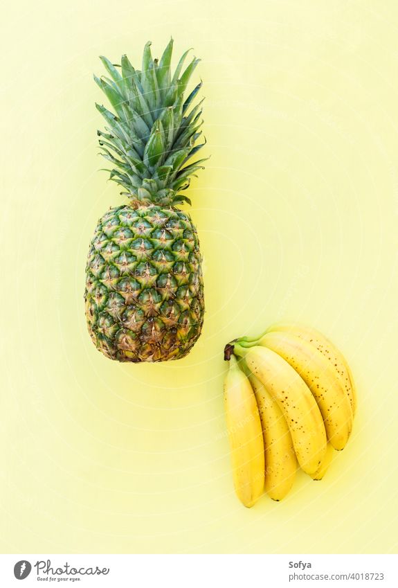 Ganze Ananas-Bananenfrucht auf gelbem Hintergrund, Ansicht von oben Haufen reif frisch Frucht Sommer grün organisch Textur schließen Menschengruppe Vorbau süß