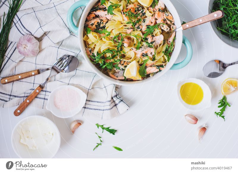Italienische Küche - cremige Lachsnudeln mit Rucola, Spinat und Käse, serviert mit Zitrone Lebensmittel Spätzle Abendessen Fisch Mittagessen Saucen Gesundheit