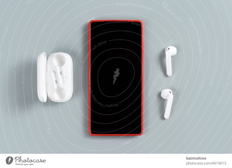 Rotes Handy und weiße kabellose Ohrhörer rot Smartphone Drahtlos Deckung Attrappe Kopfhörer Draufsicht Hintergrund Zubehör tragbar Mobile Telefon Fotohandy