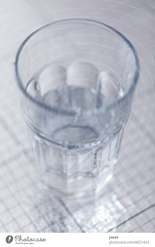 Glas Wasser, halbvoll, auf glänzender Oberfläche trinken Durst Wasserglas Trinkglas Gefäß Flüssigkeit Gesundheit Ernährung Maßvoll frisch Farbfoto
