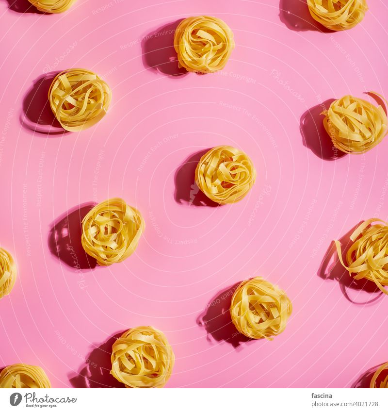 Pasta Kunst mit Tagliatelle auf rosa Hintergrund Spätzle Muster kreativ Layout Top Ansicht flach legen Quadrat Ernte Draufsicht flache Verlegung