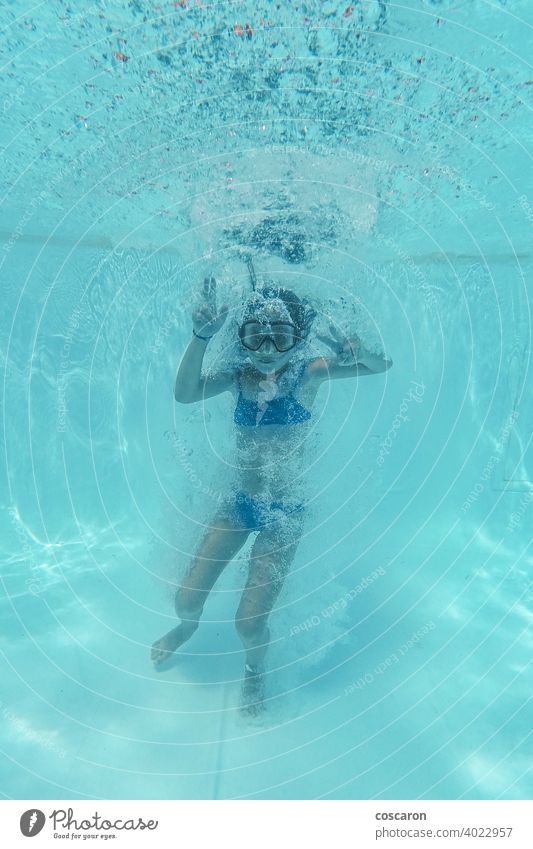 Kleines Mädchen springt in einen Pool und taucht Aktion Aktivität Aquapark aquatisch blau Blasen Kind übersichtlich Konzept Textfreiraum tief im Inneren Tauchen