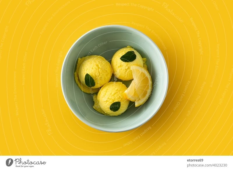 Zitroneneiskugel, dekoriert mit Minzblättern in Schale kalt cremig Molkerei lecker Dessert Lebensmittel frieren Speiseeis eisbedeckt vereinzelt Minze
