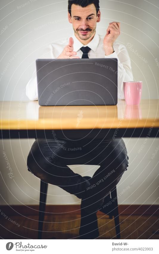 gut gelaunter Mann sitzt vor einem Laptop Gute Laune positiv optimistisch zufrieden Homeoffice zu Hause Arbeitsplatz Quarantäne Notebook arbeiten online