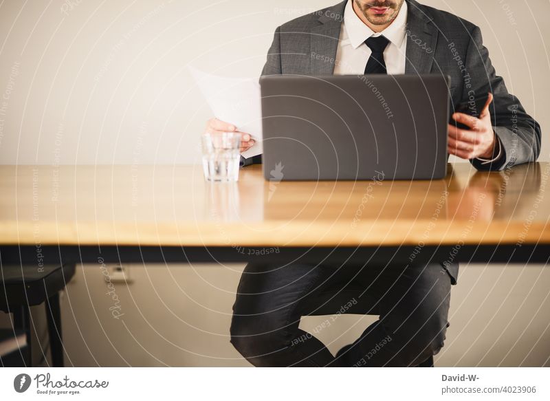 arbeitender Mann am Laptop Business Handy kontrollieren checken Homeoffice Tisch Arbeitsplatz Notebook Anzug Technik & Technologie zuhause