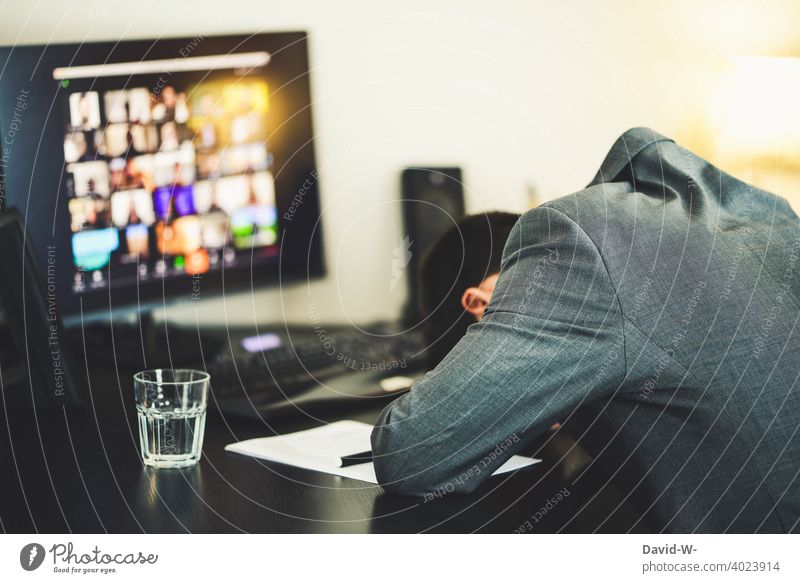 erschöpfter Mann bei der Arbeit vor dem Computer / Bildschirm müde Erschöpfung Homeoffice schlafen frust überarbeitung Meeting Konferenz Arbeitsplatz online