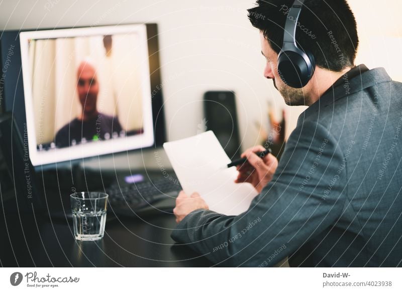 Videokonferenz am Computer online Meeting Kommunikation Homeoffice austauschen Besprechung Mann Headset Laptop Bildschirm zoom Arbeitsplatz Schreibtisch Chat