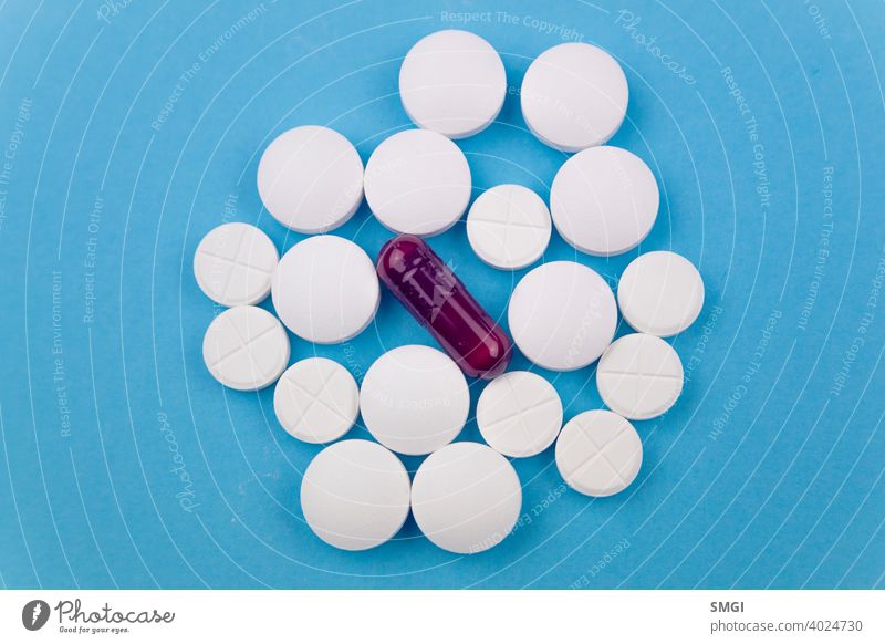 Draufsicht auf mehrere weiße und eine violette Pille. Konzept von Medikamenten zur Behandlung von Krankheiten, insbesondere gegen Covid-19 Tablette Medizin