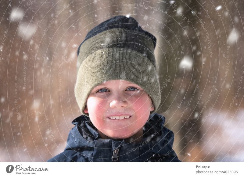 Junge im Schnee mit einer Strickmütze natürlich Wolle Kleidung hübsch gestrickt Umwelt Nahaufnahme Schneeflocke Lächeln Lifestyle Wetter frieren im Freien Frost
