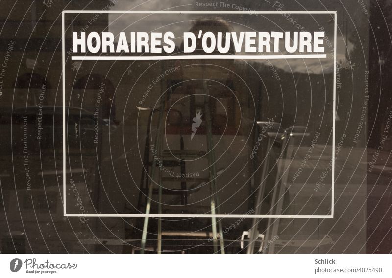 Selfie mit Atemschutzmaske vor einem leeren Schaufenster mit französischer Aufschrift "HORAIRES D´OUVERTURE" ohne Angabe der Öffnungszeiten Insolvenz Text