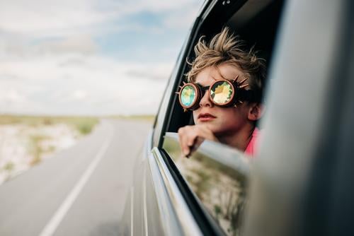 Ein Junge schaut mit einer Kaleidoskopbrille aus dem Fenster eines fahrenden Fahrzeugs Kaleidoskop-Schutzbrille Autoreise Ferien & Urlaub & Reisen