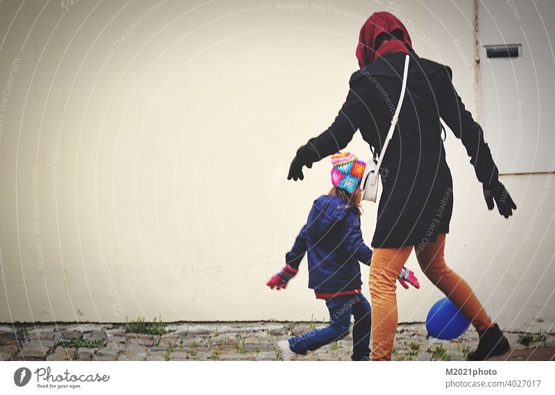 Eine Mutter und Tochter spielen mit Ballon in einer Stadt während Corona Virus Welt Pandemie Person Familie Glück jugendlich Großstadt Frau Mode Mädchen