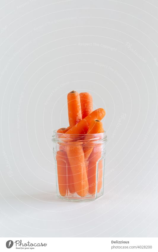 Gruppe von orangefarbenen Karotten in einem Glasgefäß auf weißem Hintergrund, mit Kopierraum, veganer Snack Gesundheit Farbe Vitamin Frische oben Frühstück