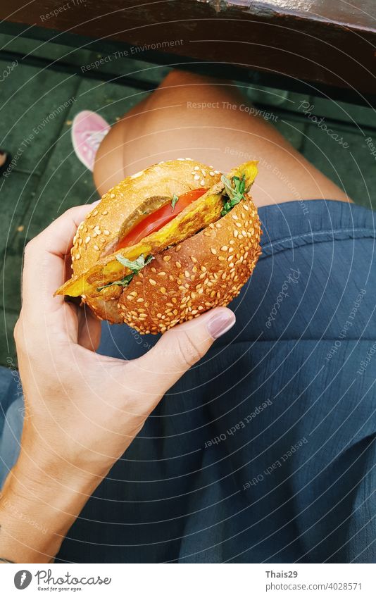 Junges Mädchen hält in weiblichen Händen Fast-Food-Burger, gesunde Kalorien Mahlzeit, hungrige Frau mit gegrillten Hamburger Draufsicht schnell Lebensmittel