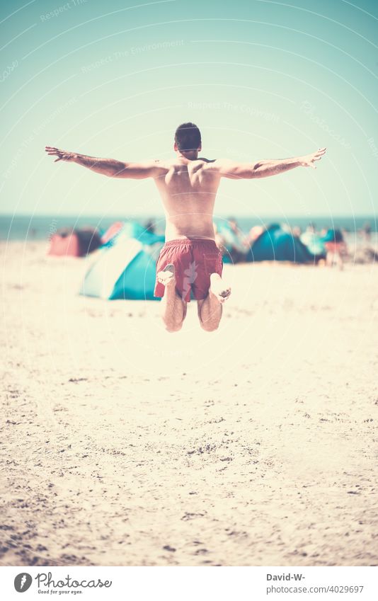 Happy an einem Sommertag am Strand Luftsprung Urlaub Sommerurlaub Urlaubsstimmung Meer Freude Fröhlichkeit happy Springen Muskeln Mann