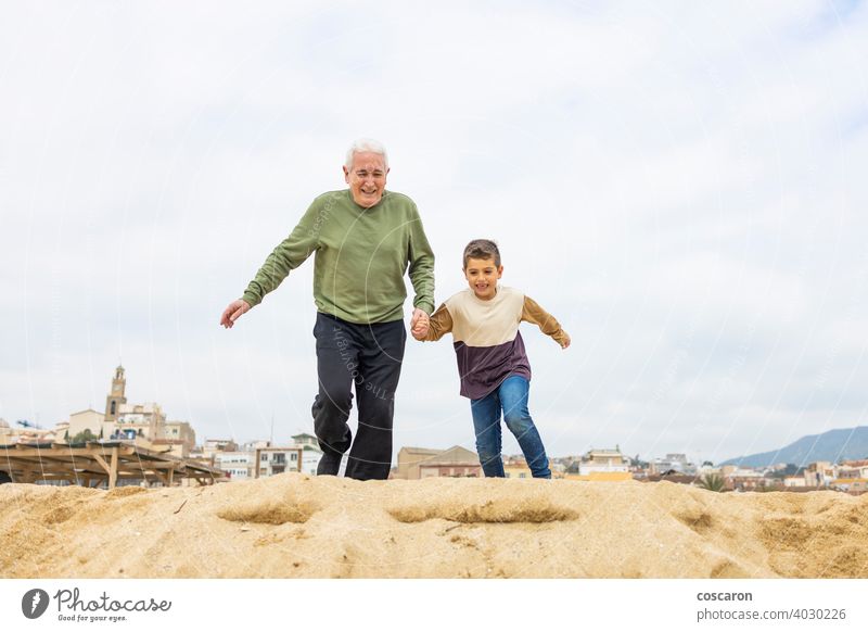 Kleiner Junge und sein Großvater laufen am Strand aktiv Erwachsener Kaukasier Kind Kindheit Kinder älter genießend Familie Generationen Enkelkind Opa Großeltern