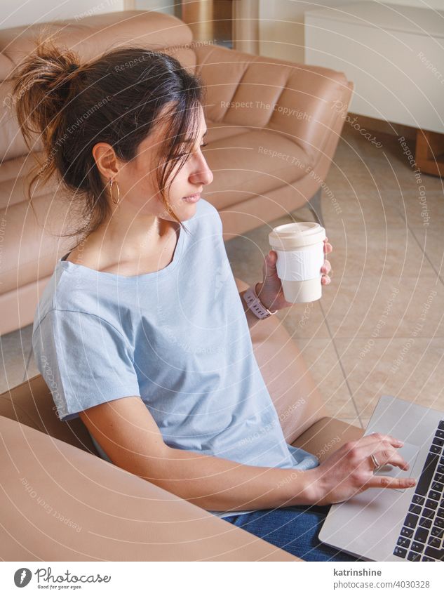 Junge Frauen arbeiten mit Laptop, während sie zu Hause auf dem Sofa sitzen jung anhaben Attrappe T-Shirt lernen Schüler Lifestyle Jeanshose Kaffee zum Mitnehmen