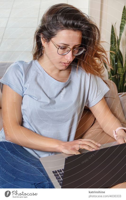 Junge Frauen verwenden einen Laptop, während sie zu Hause auf dem Sofa sitzen jung anhaben Attrappe T-Shirt lernen Schüler Lifestyle Jeanshose Brille ernst