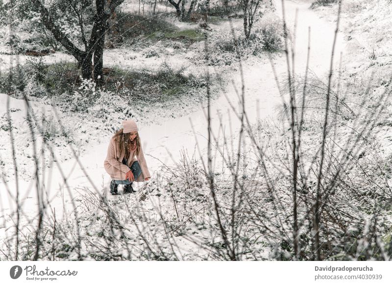schöne Frau berührt Schnee im Wald Winter genießen Lächeln warme Kleidung Inhalt Wochenende Wälder Winterzeit Schneefall heiter Glück Optimist positiv Hut