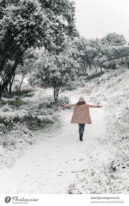 Unerkennbare Frau geht im Winterwald Spaziergang Wald sorgenfrei ausdehnen genießen schlendern Schnee warme Kleidung Winterzeit Wochenende Wälder Freiheit Hut
