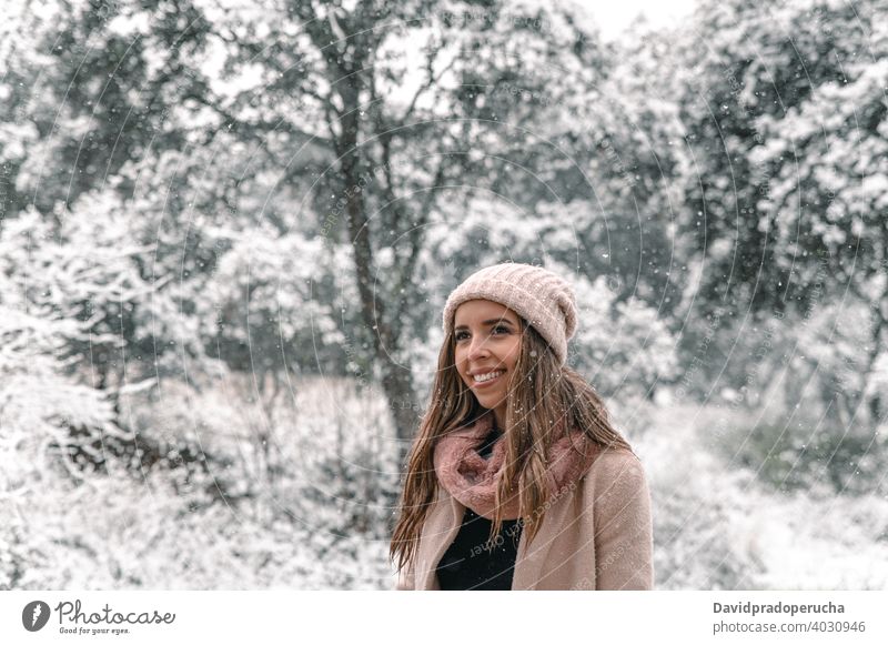 Frau in Oberbekleidung zu Fuß in verschneiten Wäldern Winter Wald Spaziergang sorgenfrei genießen Schnee Winterzeit Schneefall schlendern Lächeln Inhalt