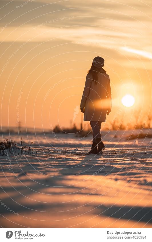 Frau genießt Sonnenuntergang im verschneiten Feld Winter Landschaft Schnee Natur allein Saison genießen frisch kalt Erholung Lifestyle Wetter Winterzeit