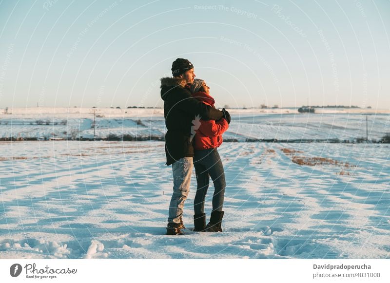 Paar umarmt in verschneiten Feld Kuss Winter Schnee Landschaft Liebe romantisch Zusammensein Partnerschaft Umarmung Zuneigung Umarmen amourös Angebot Bonden