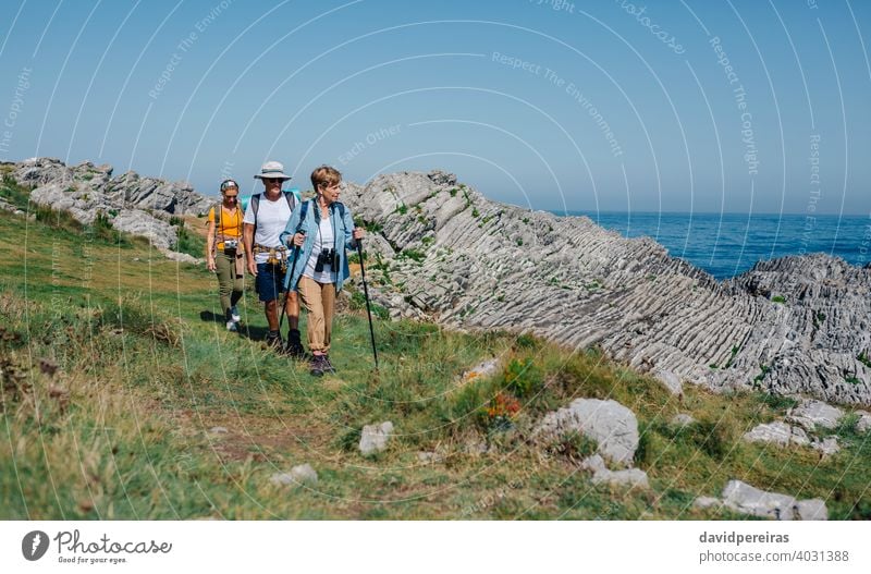 Drei Personen, die Trekking im Freien praktizieren Wanderer Landschaft Menschengruppe MEER Nordic Walking Blick Natur Trekkingstöcke laufen Sommer Wanderung